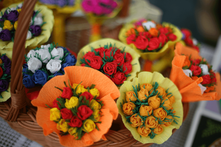 Bukiety kolorowych róż wykonanych z bibuły w koszyku wiklinowym